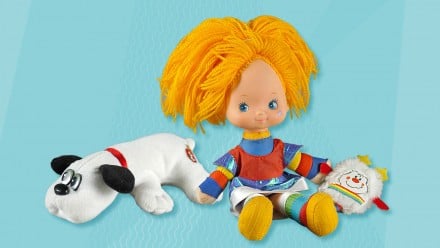 蓝色背景与80年代的玩具，包括彩虹Brite娃娃和磅小狗