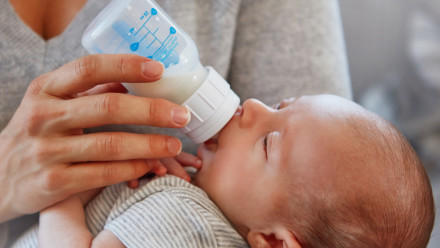 一个母亲用奶瓶喂她刚出生的婴儿的特写镜头