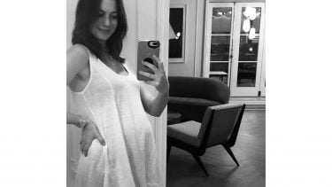 安妮·海瑟薇在家里的镜子前自拍她怀孕的肚子