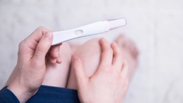 怀孕3周:孕妇低头看验孕棒