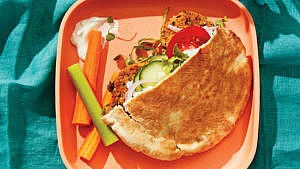沙拉三明治皮塔饼放在圆角方形盘子上的照片