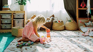 一个孩子在白色地毯上玩玩具
