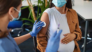 孕妇戴着口罩接种疫苗