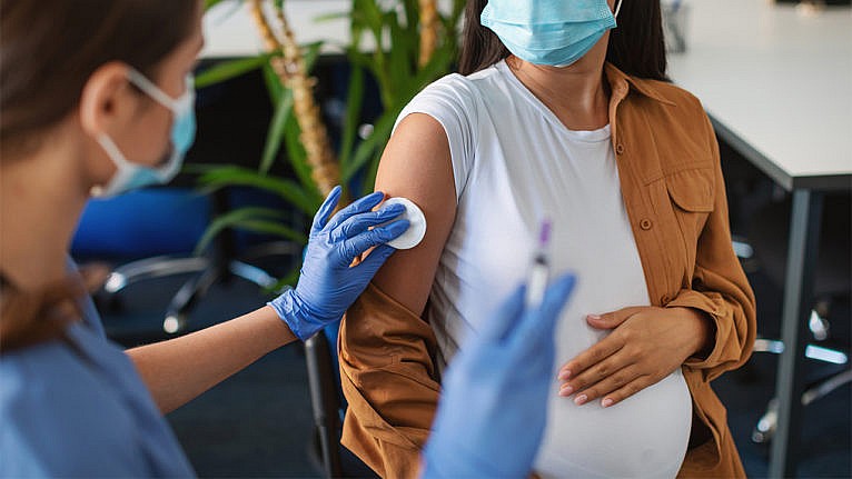 孕妇戴着口罩接种疫苗