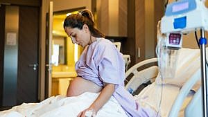 一个穿着紫色病号服的孕妇准备分娩