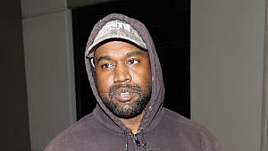 一张坎耶·韦斯特(Kanye West)穿着灰色连帽衫、戴着帽子的照片。