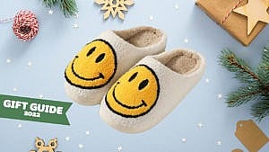 一套毛茸茸的拖鞋，上面有笑脸，背景是节日主题。