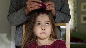 一位母亲用除虱梳检查女儿的头发是否有头虱