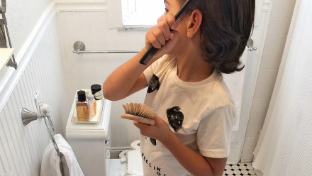 小孩在浴室镜子前梳头
